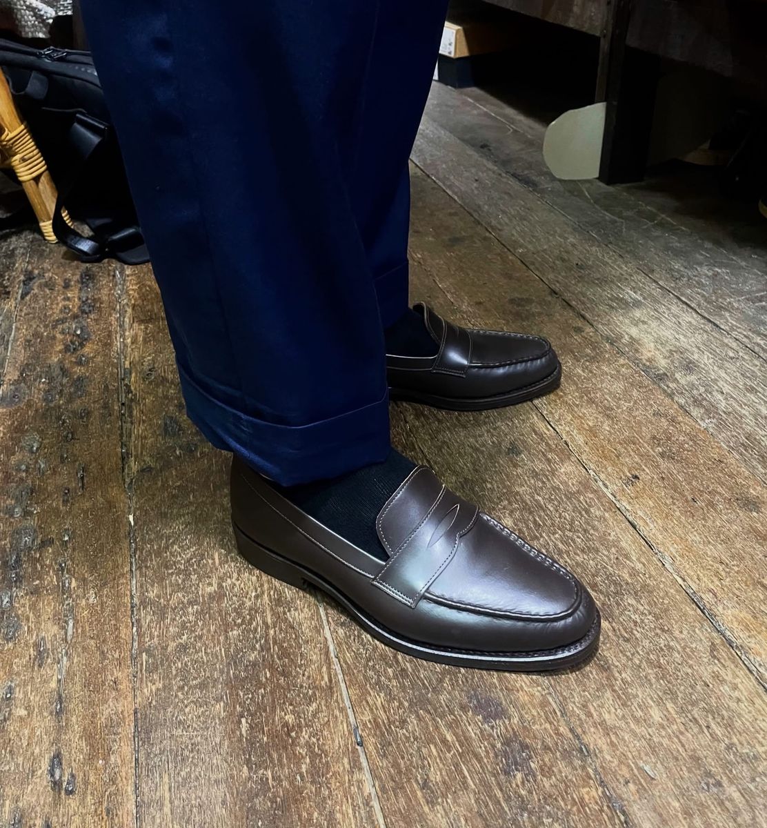 Dark brown penny loafers, worn by a client