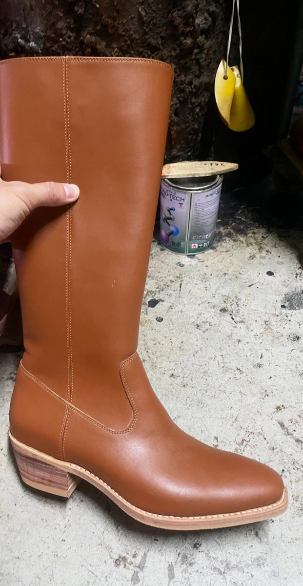 Tall tan boot with a stacked heel and welted sole